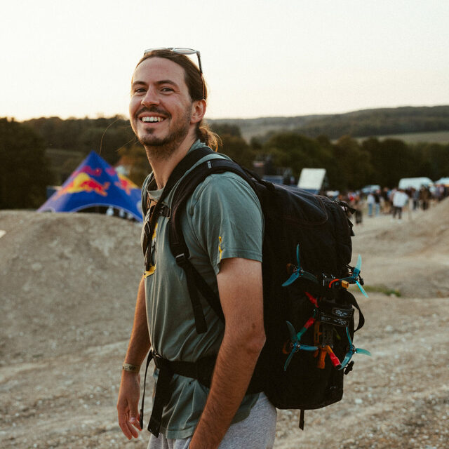Robin Cretinon, filmmaker and FPV pilot, with his backpack in the mountains